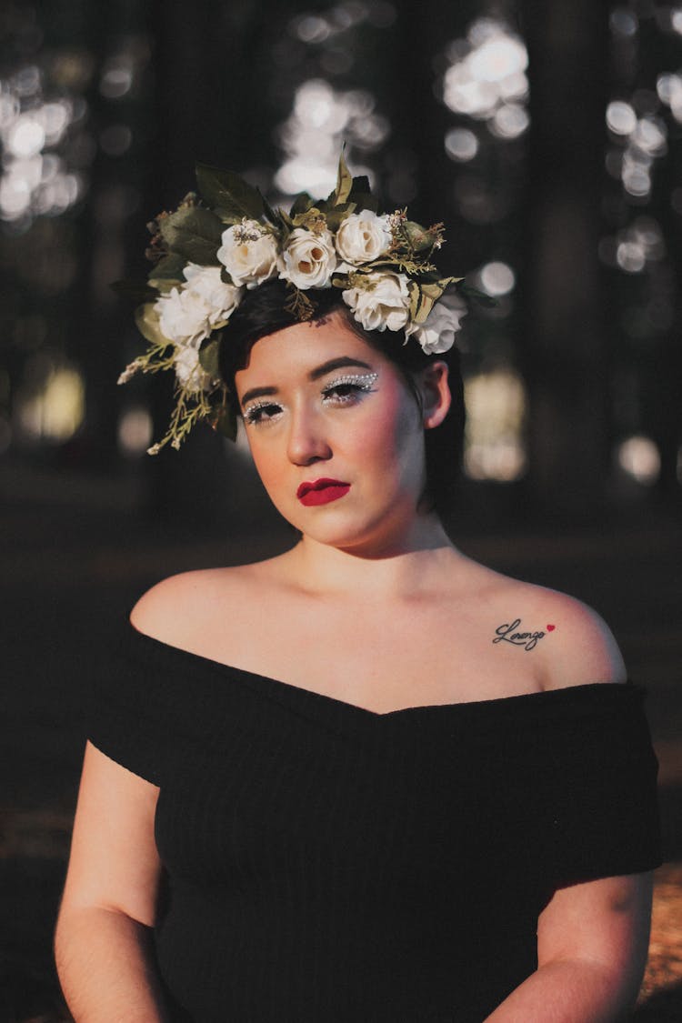 Young Brunette Woman In Black Sleeveless Dress And With Flower Crown On Head 