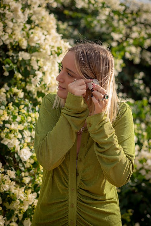 Photo of a Woman Putting a Flower on Her Ear