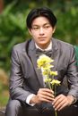 Man in a Gray Suit Holding Yellow Flowers
