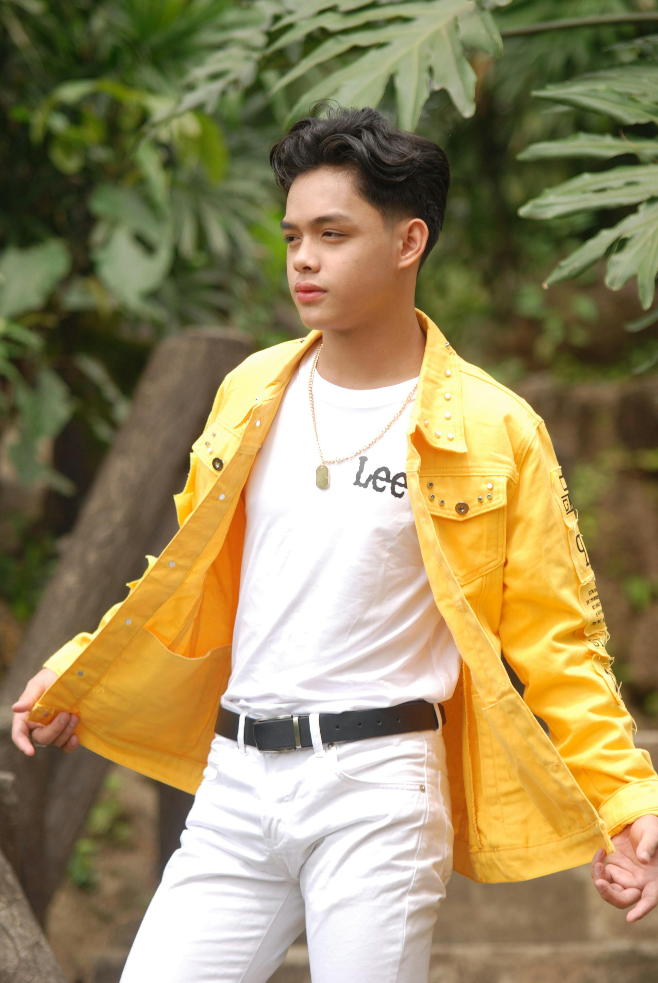 a man wearing yellow shirt and black pants and white shoes Stock Photo by  Icons8