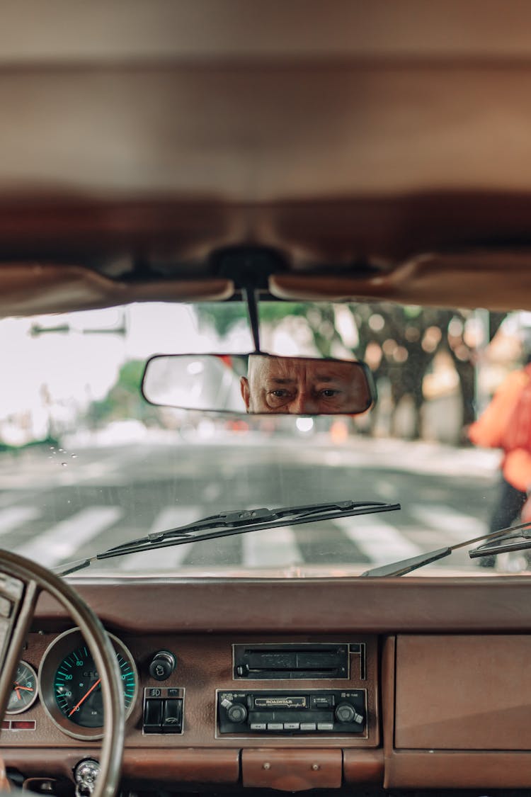 Eyes Of Elderly Man In Rear View Mirror