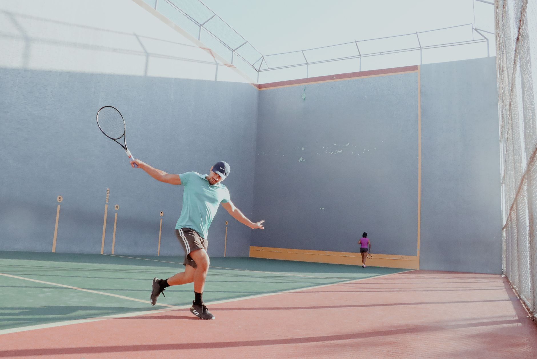 A male tennis player swinging a racket on an outdoor court with vivid colors.