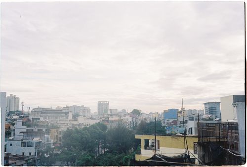 Free Cityscape view of urban skyline featuring residential and office buildings under a cloudy sky. Stock Photo