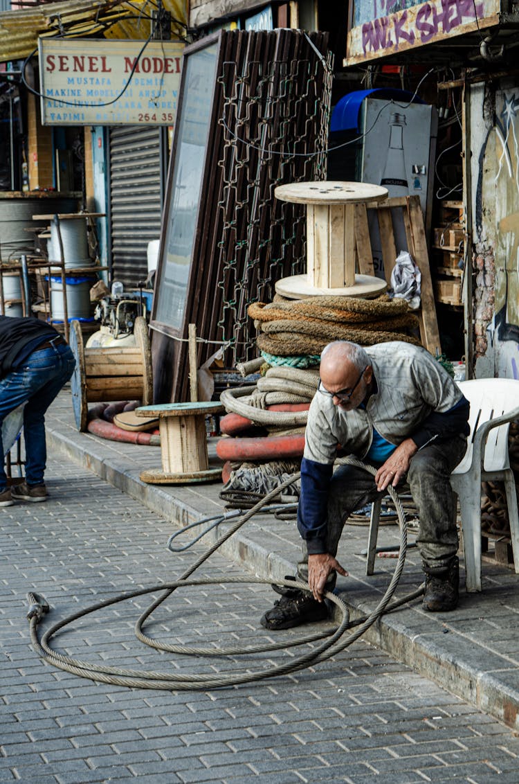 Man Holding A Hose In Front Of A Shop