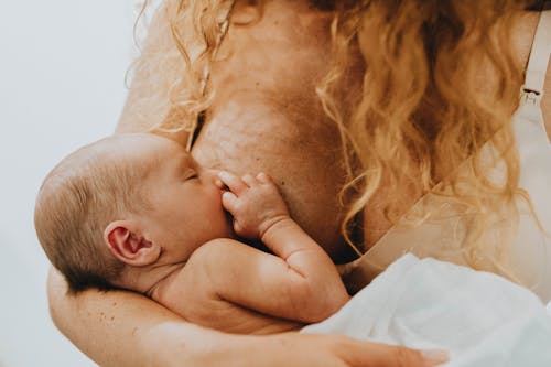 Free Woman Holding Child and Breastfeeding  Stock Photo