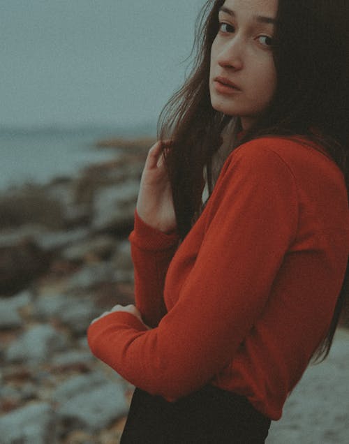 Portrait of a Woman in a Red Top Touching Her Hair