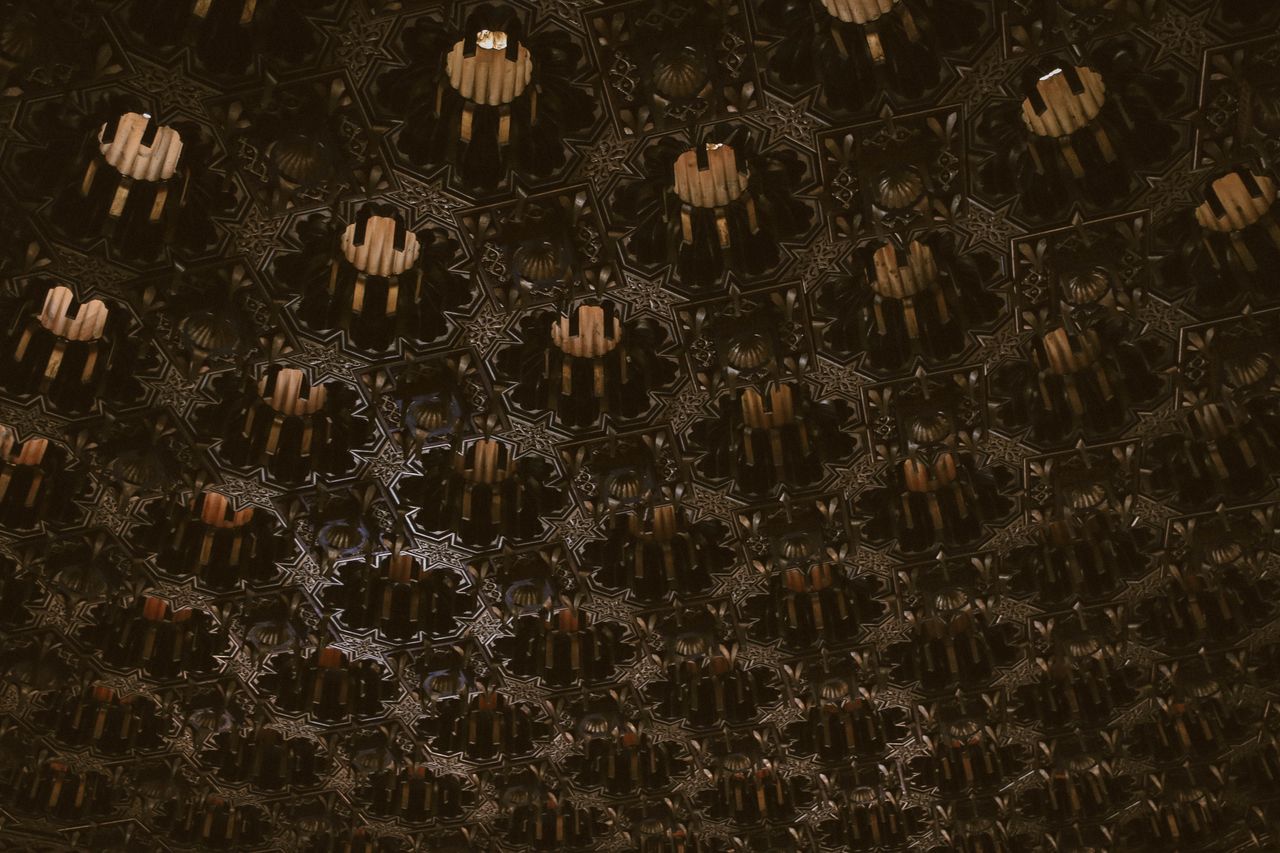 a detailed abstract ceiling with islamic geometric patterns and dark t