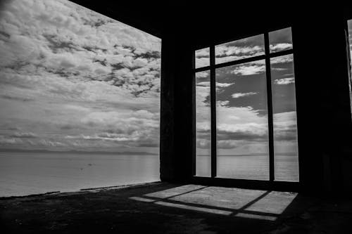 Grayscale Photo of an Abandoned Building Near Sea