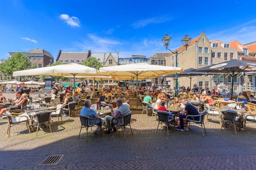 在荷兰多德雷赫特的一家户外咖啡馆，人们正享受着阳光明媚的一天