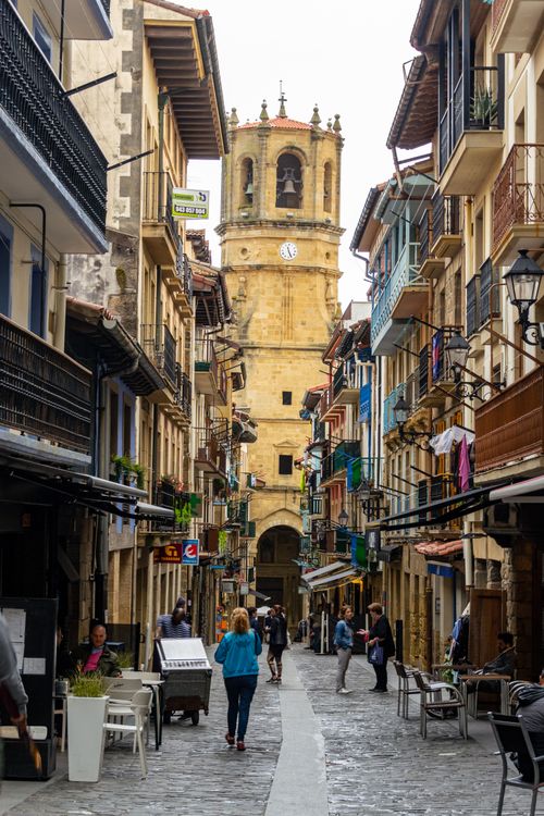 Free A bustling urban street with historical architecture and people walking. Stock Photo
