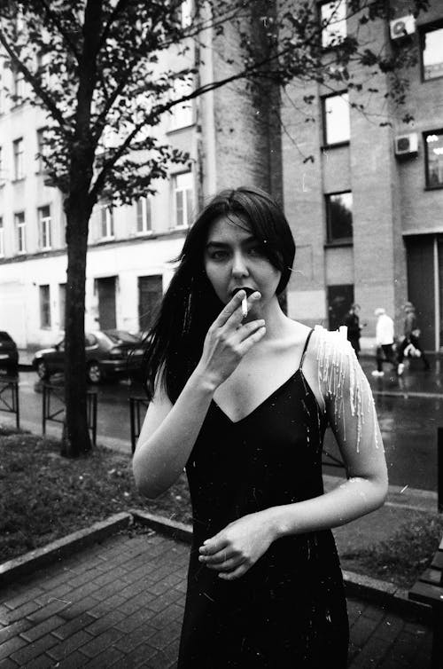 Grayscale Photo of a Woman Smoking a Cigarette