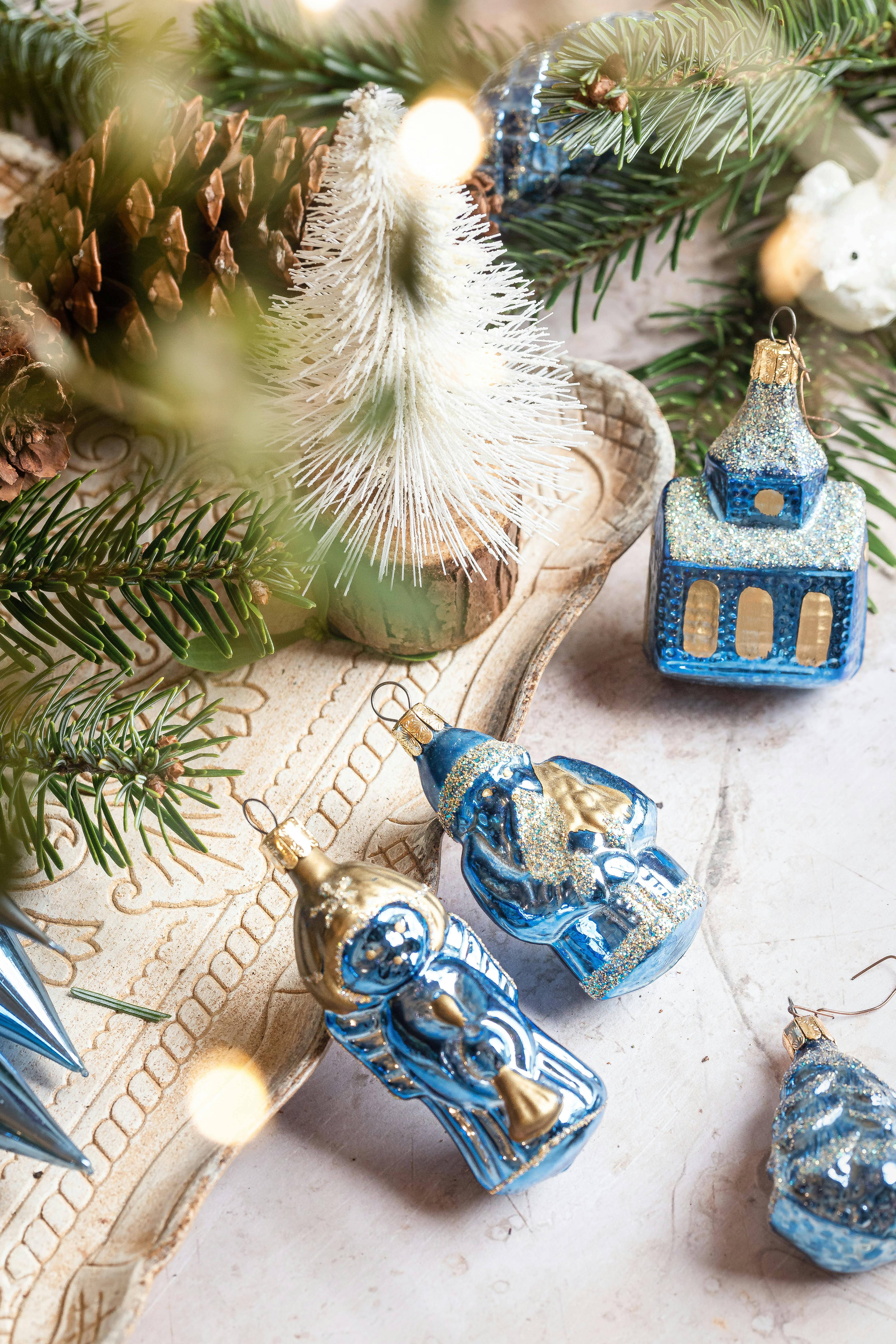 Close-up of blue and gold Christmas ornaments with fir branches and festive decor.