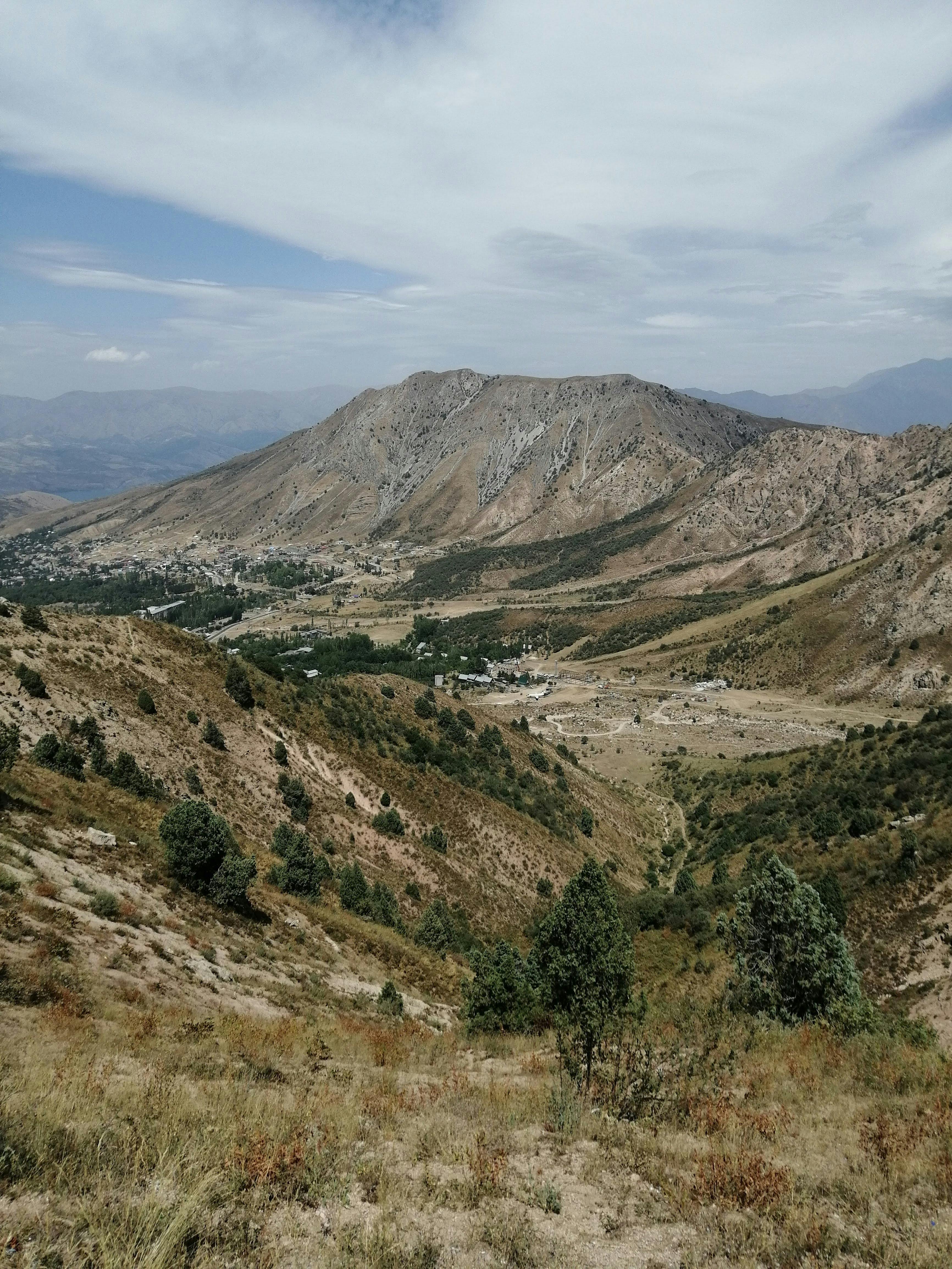 A picturesque mountain landscape featuring a vast valley and lush trees, perfect for nature enthusiasts.