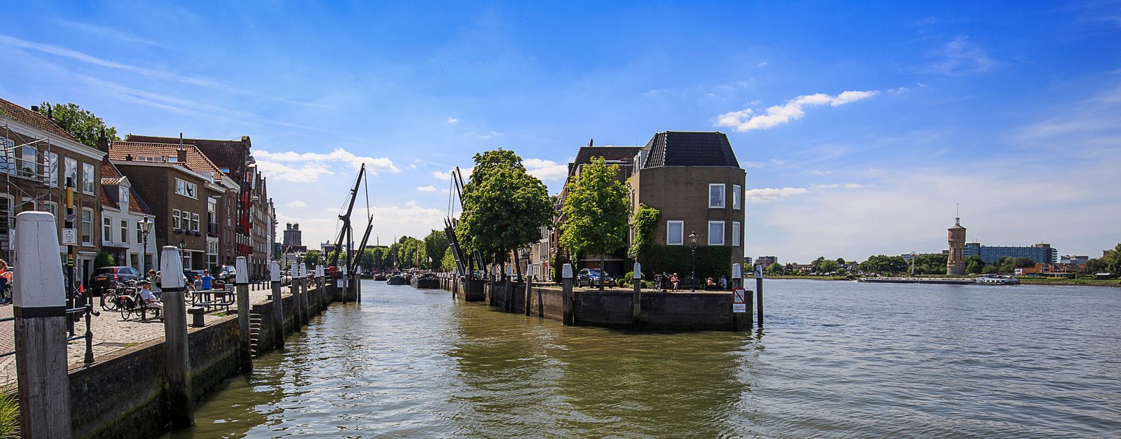 Picturesque view of Dordrecht's waterfront with historic buildings and clear sky.