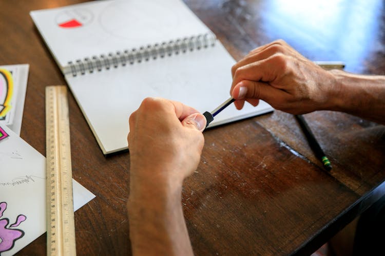 Close-up View Of Man Sharpening Pencil