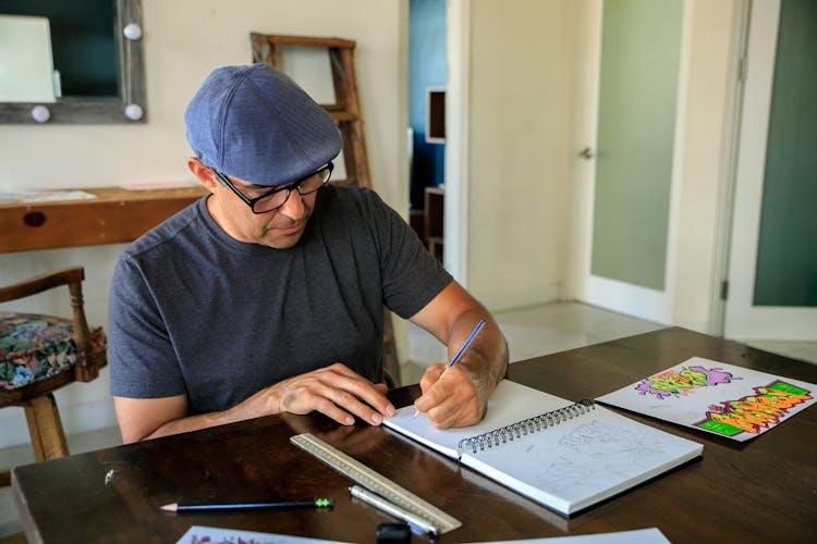 Man Drawing In Spiral Notebook