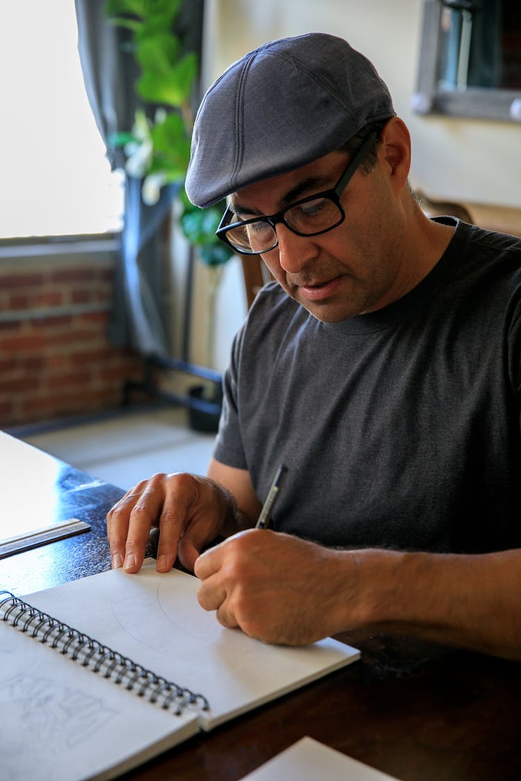 Artist Drawing With Pencil In Spiral Notebook