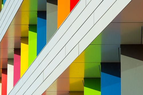 Free Vibrant modern architectural facade with geometric patterns and rainbow colors. Stock Photo