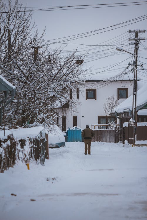 A Man Walking in the Suburbs during Winter