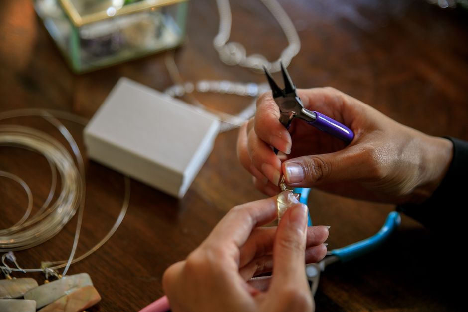 A close-up of intricate filigree jewelry being crafted in an Albanian workshop