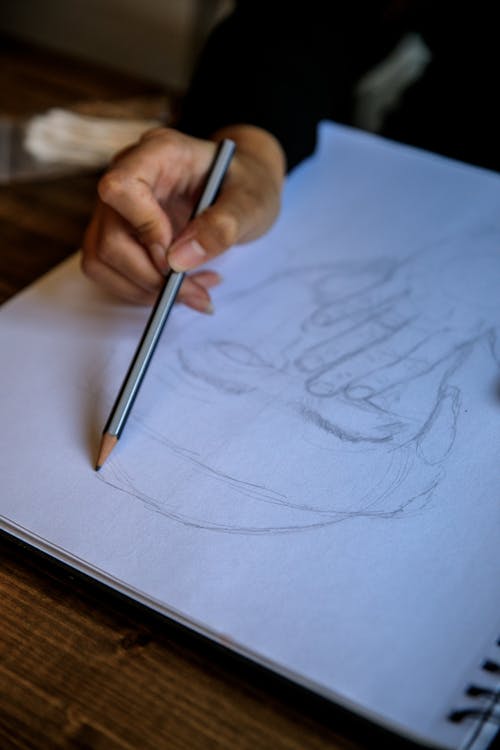 Artist Sketching in Spiral Notebook