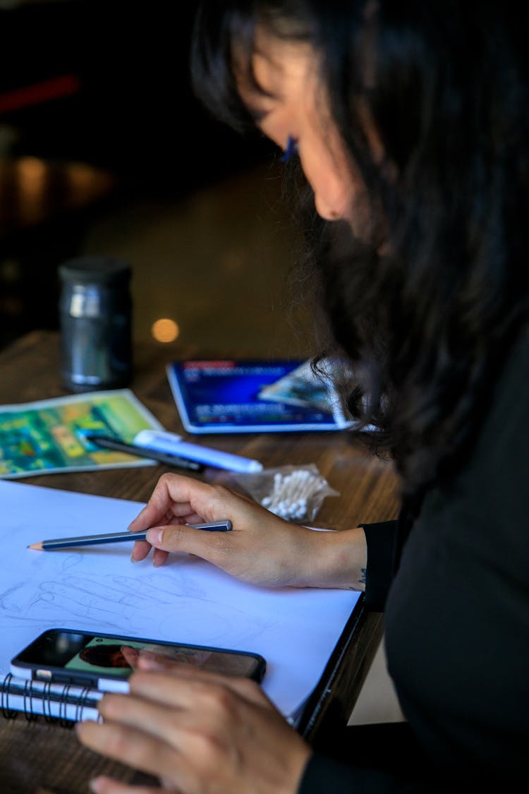 Woman Drawing And Looking At Phone