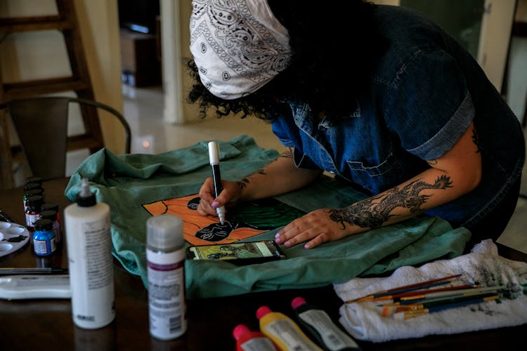 Woman In Denim Shirt Painting On Cloth