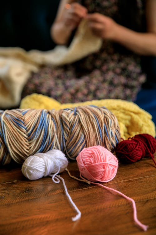 Balls of Wool and Person Knitting behind