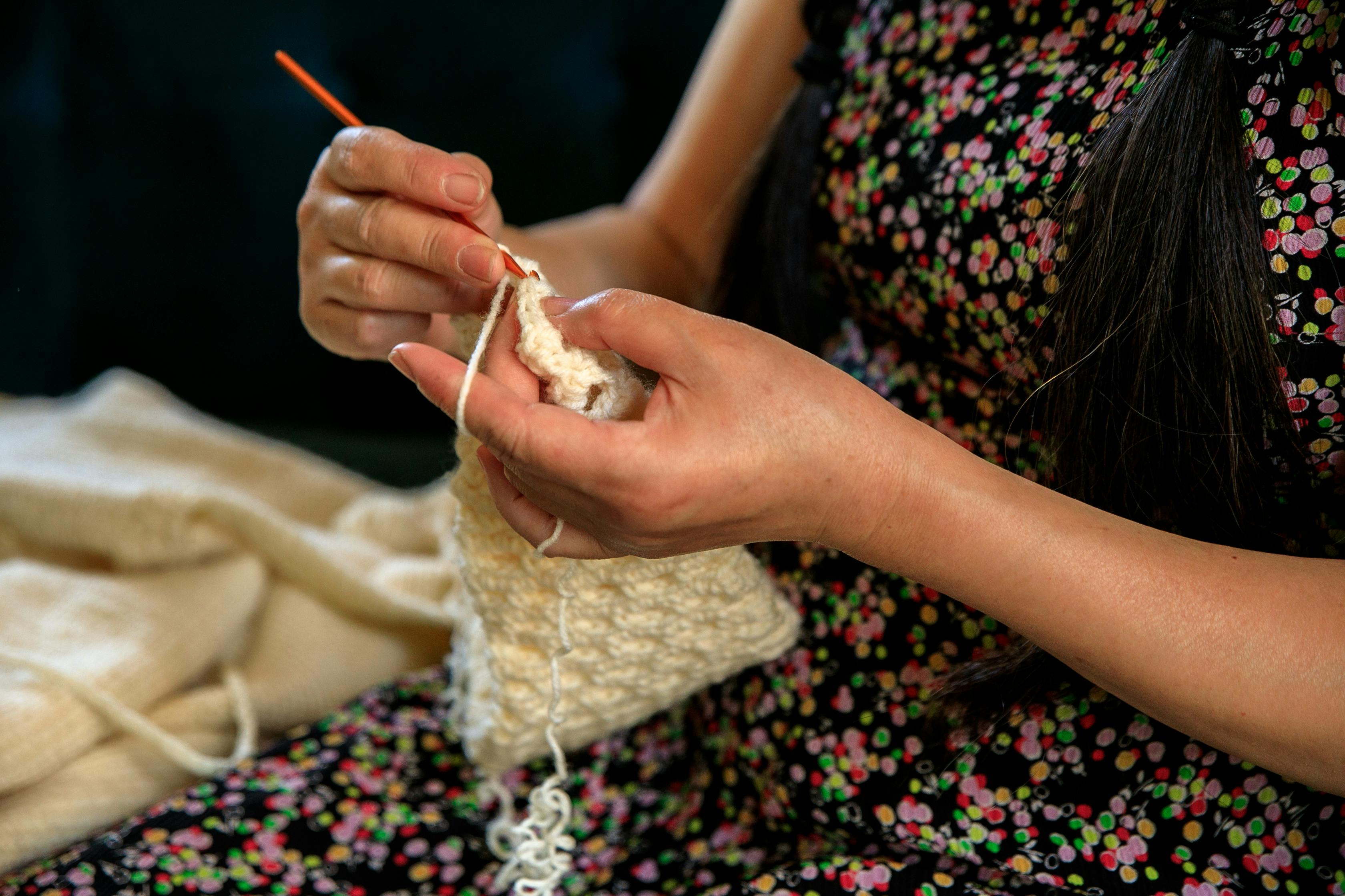 A woman skillfully crochets with yarn, showcasing her craft and creativity.