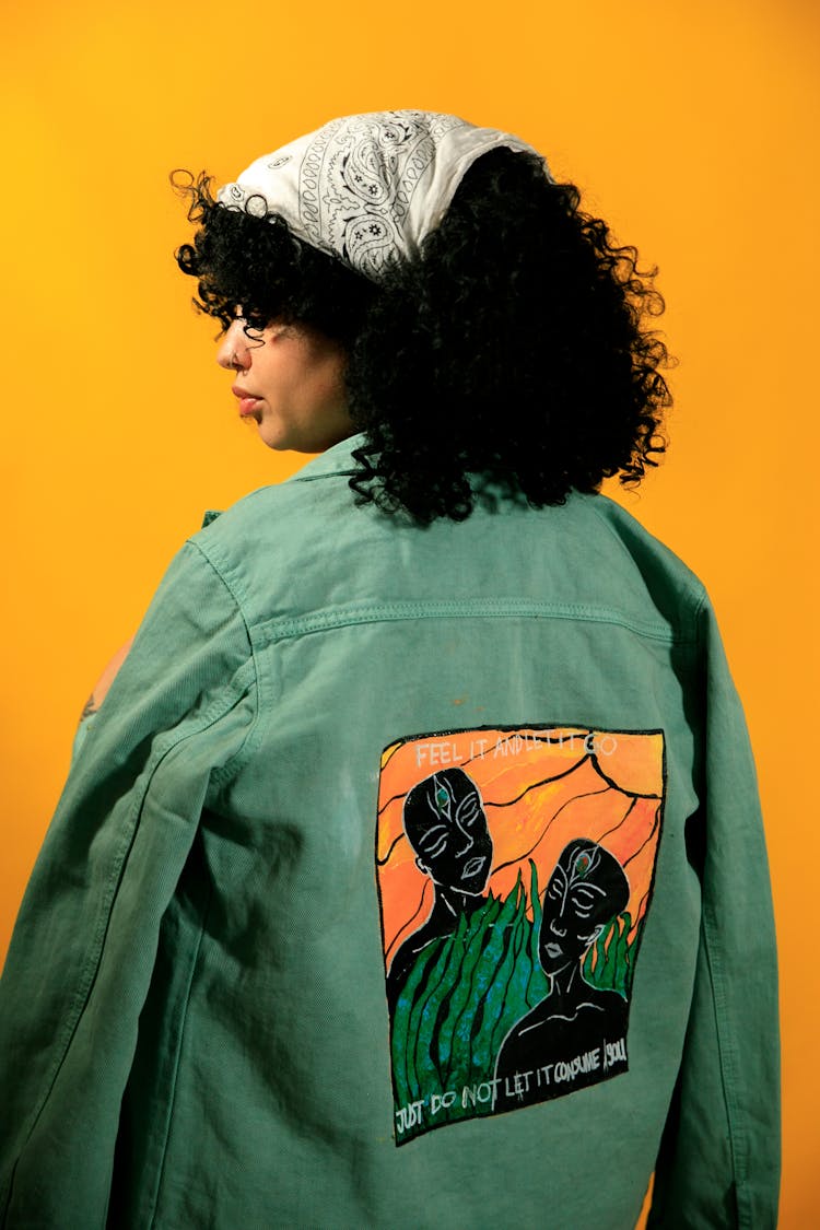 Woman In Painted Jacket On Yellow Background