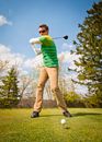 Man in Green and White Stripes Long Sleeve Shirt Holding Black Golf Club