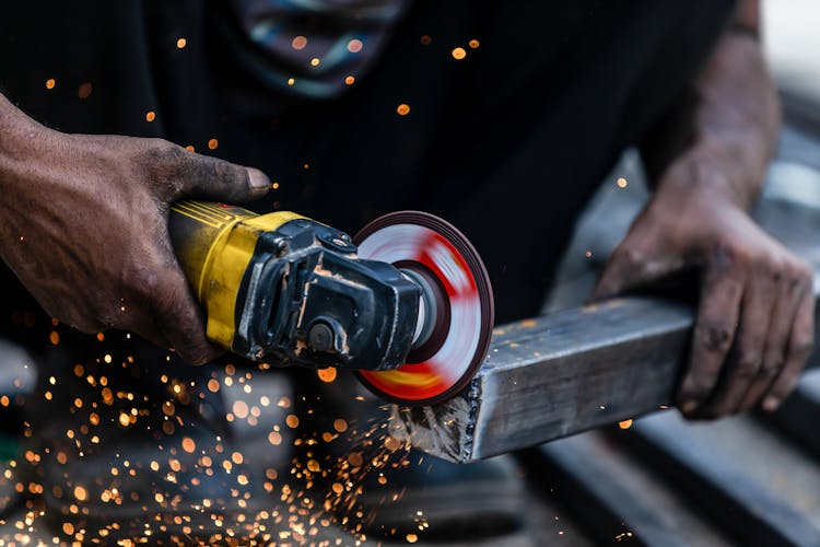 Person Grinding The Metal 