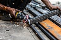 Person Grinding the Metal Using Hand Grinder