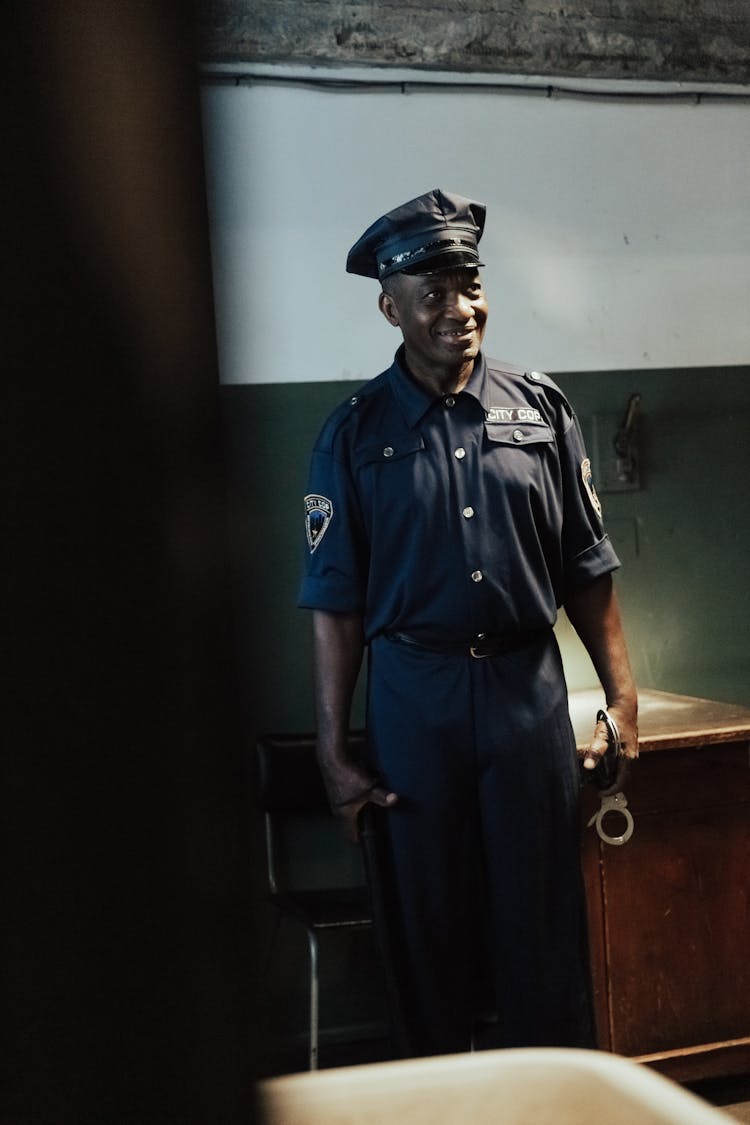 A Policeman Holding A Police Baton And Handcuffs