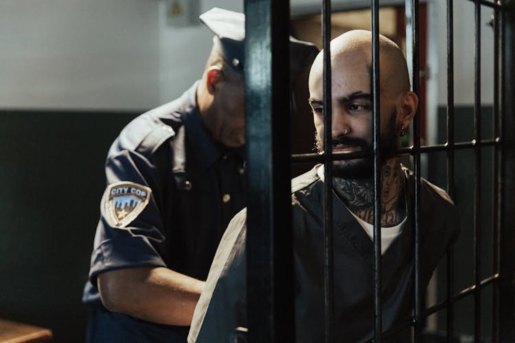 Man In Black Shirt Standing Beside Bars