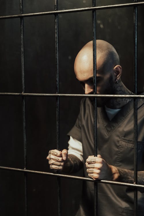 Man in Black Shirt Holding Black Metal Bars