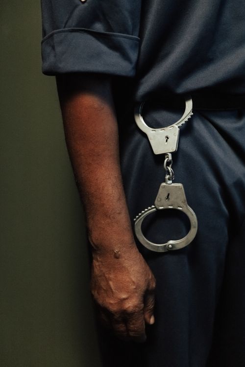 Free Close-up of a policeman with handcuffs hanging over his belt, ready for duty. Stock Photo