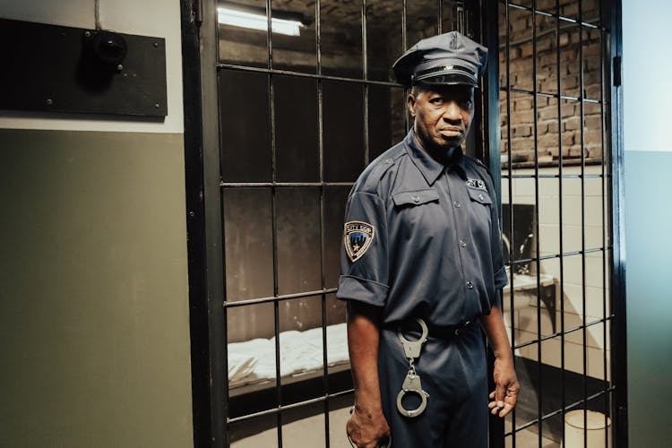 A Jail Guard Standing In A Prison Cell