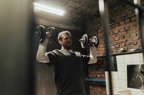 Free Man in Gray Crew Neck T-shirt Holding Black Kettle Bell Stock Photo