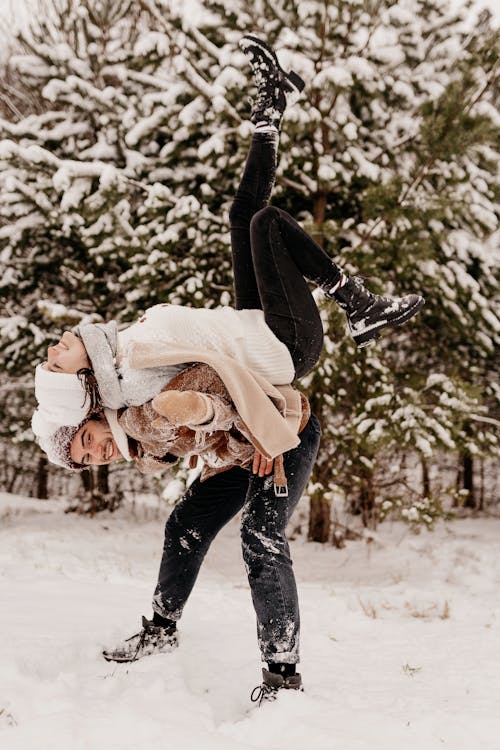 Free Man with Woman on Back on Snow Stock Photo
