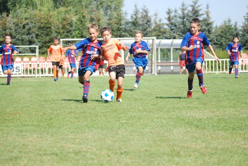 Boys Playing Soccer on Football Stadium