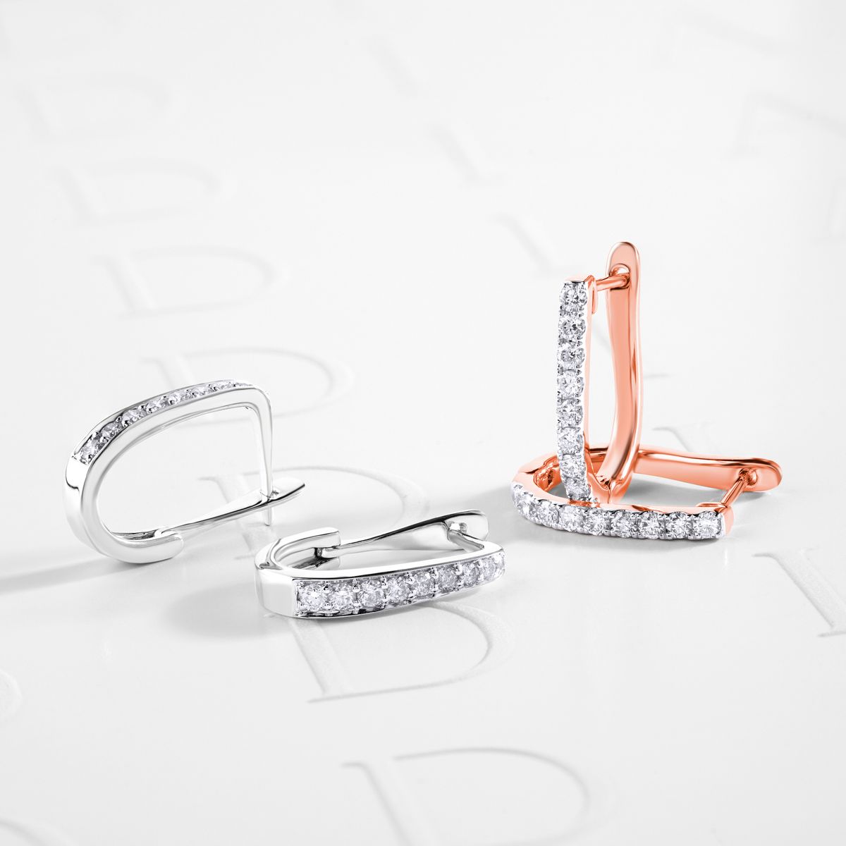 Diamond earrings displayed on a light surface for a close look at their setting and profile