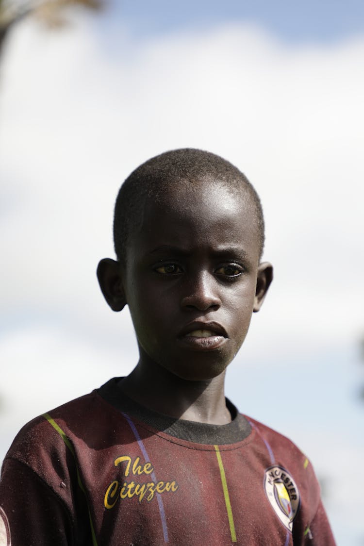 A Boy Wearing A Dirty Red Jersey