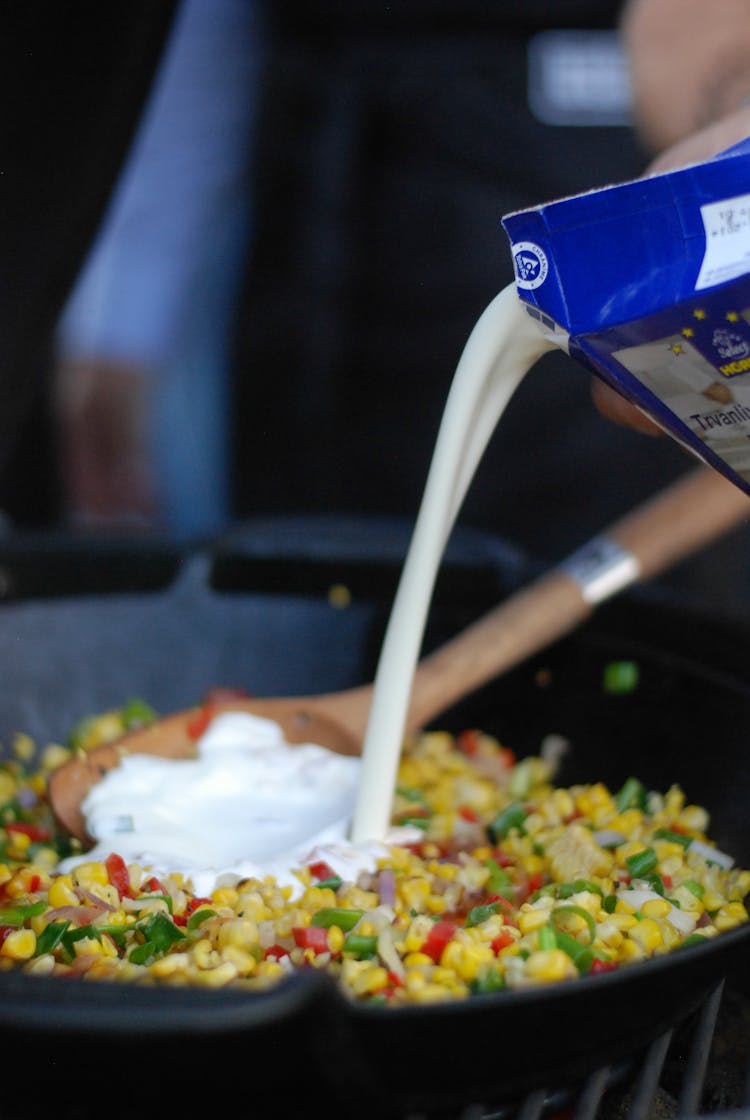 Person Pouring Milk In A Pan