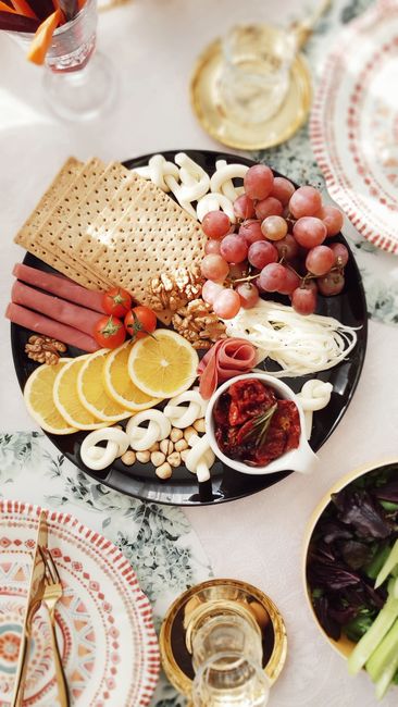 Elegant platter featuring grapes, nuts, and sliced oranges for a sophisticated snack.