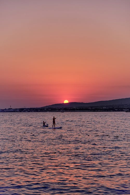 Silhouette of People on the Sea during Golden Hour 