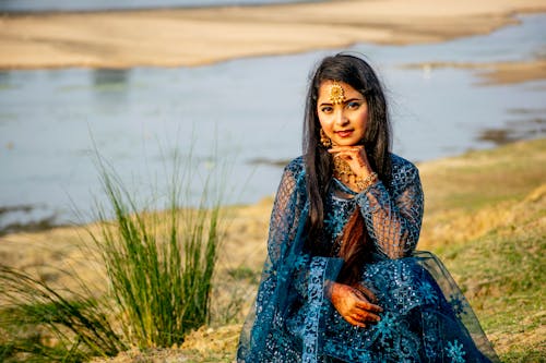 Young Woman in Traditional Clothing Sitting Outdoors 