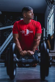 Young man working out with a kettlebell in a gym in Quatis, Brazil.