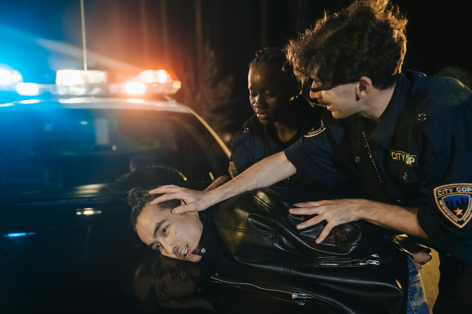 Man in Police Uniform Arresting a Man in Black Leather Jacker