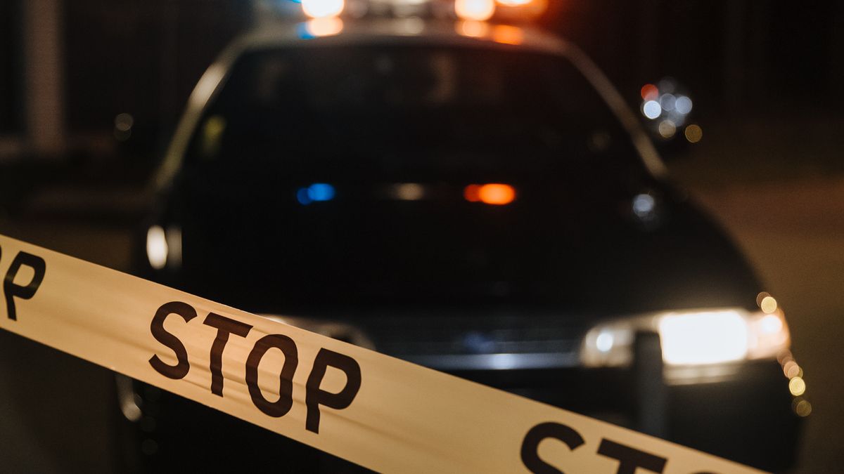 Viatura policial atrás de faixa de isolamento durante uma investigação.